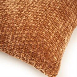 Close-up van een bruin, geweven kussen met een zachte textuur, perfect voor een gezellige woonkamer of slaapkamer.