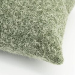 Close-up van een zacht groen viltkussen met een textuurrijke, wollige uitstraling, perfect voor een gezellige en natuurlijke interieurstijl.