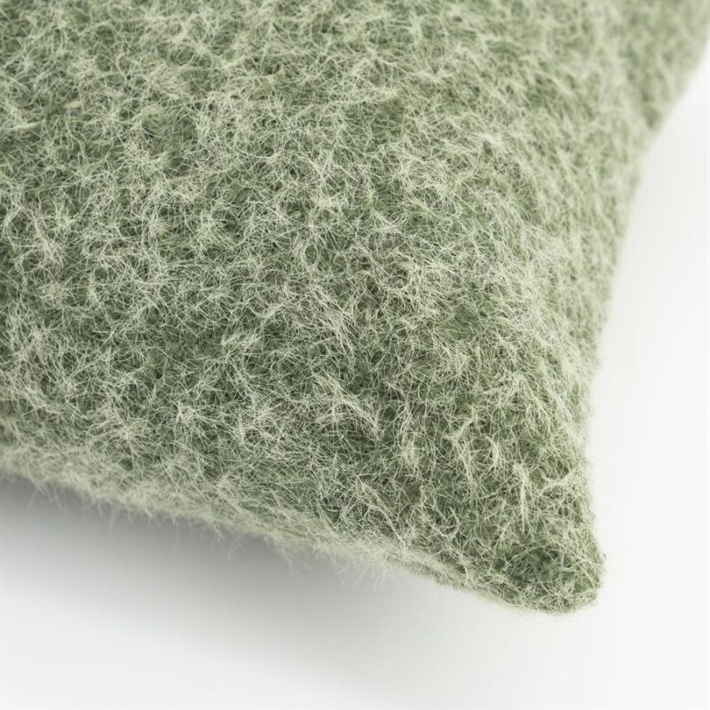 Close-up van een zacht groen viltkussen met een textuurrijke, wollige uitstraling, perfect voor een gezellige en natuurlijke interieurstijl.