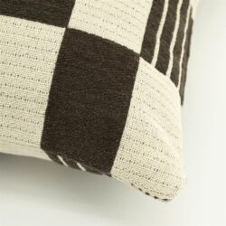 Detailopname van bruin katoenen sierkussen met twist textuur en geweven structuur