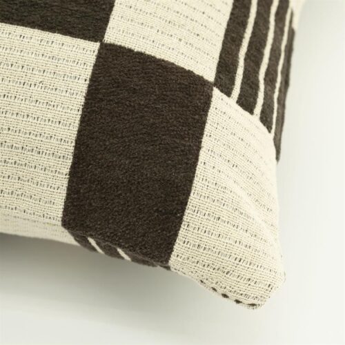 Detailopname van bruin katoenen sierkussen met twist textuur en geweven structuur