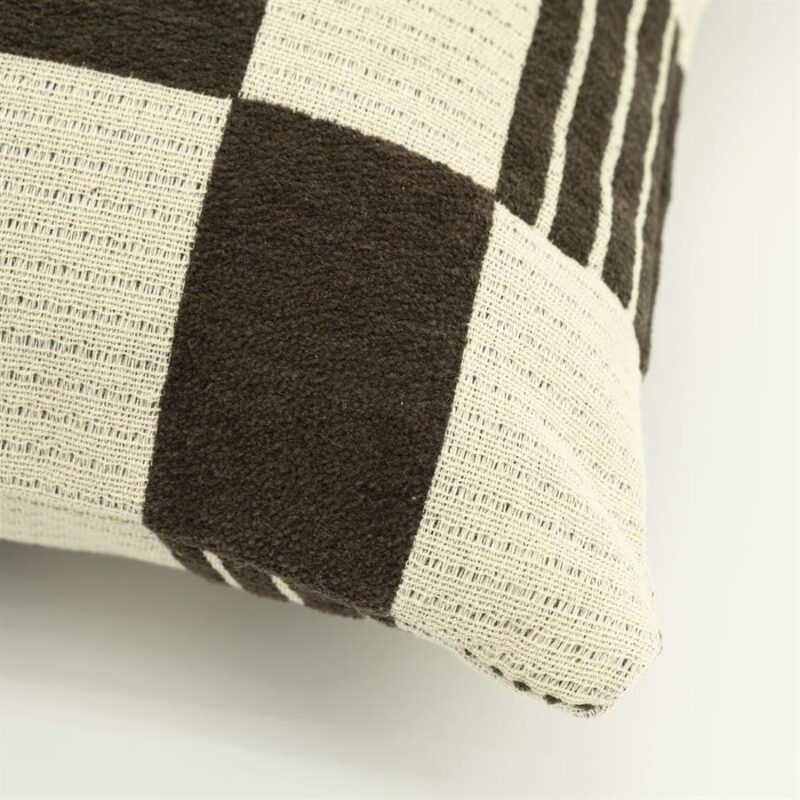 Detailopname van bruin katoenen sierkussen met twist textuur en geweven structuur