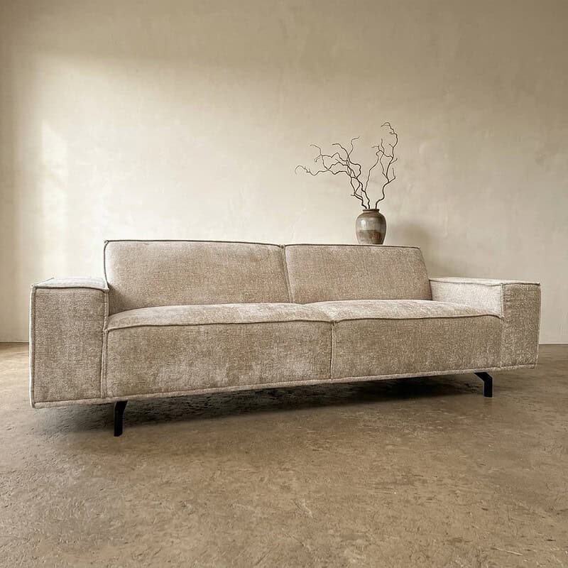 Luxe stoffen bank in een modern interieur, perfect voor woonkamer decoratie, met strakke lijnen en comfortabele zitplaatsen.