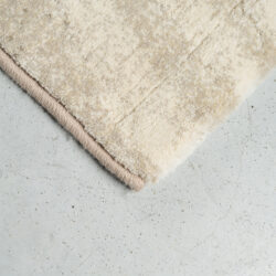 Beige vloerkleed van hoge kwaliteit op betonnen vloer, perfect voor een moderne woonkamer of slaapkamer, voegt warmte en stijl toe aan elk interieur.