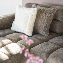 Comfortabele stoffen bank met meerdere kussens voor een gezellige zithoek. Perfect voor ontspanning en stijl in uw woonkamer.