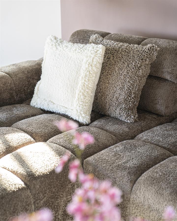 Comfortabele stoffen bank met meerdere kussens voor een gezellige zithoek. Perfect voor ontspanning en stijl in uw woonkamer.