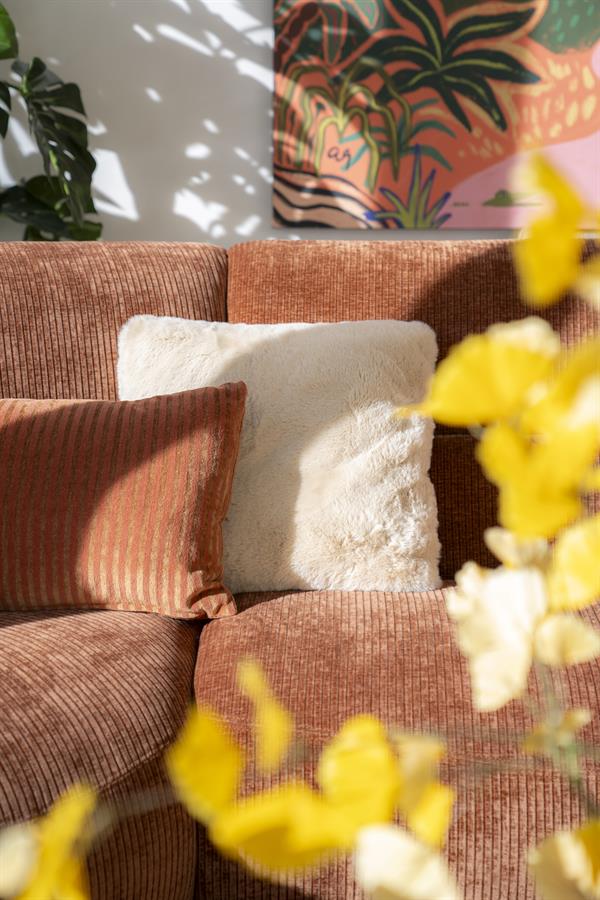 Gezellige stoffen bank met comfortabele kussens in een modern interieur, perfect voor een warme en uitnodigende woonkamer.