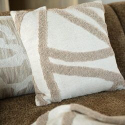 Comfortabel kussen met moderne geometrische patronen op een bank, perfect voor een stijlvolle woonkamer.