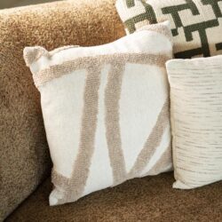 Drie decoratieve sierkussens op een bank, met verschillende patronen en texturen, perfect voor een stijlvolle en comfortabele woonkamer.