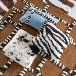 Stijlvol dierenprint vloerkleed met zebra- en luipaardmotieven, gecombineerd met kleurrijke kussens voor een trendy woonkamer uitstraling. Perfect voor een warme en gezellige sfeer.