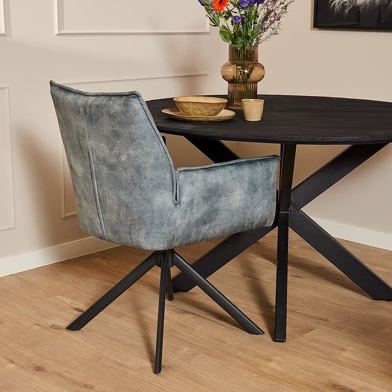 Moderne blauwe velvet eetkamerstoel met armleuningen en zwarte metalen poten, perfect voor een stijlvolle eetkamer of kantoorruimte.
