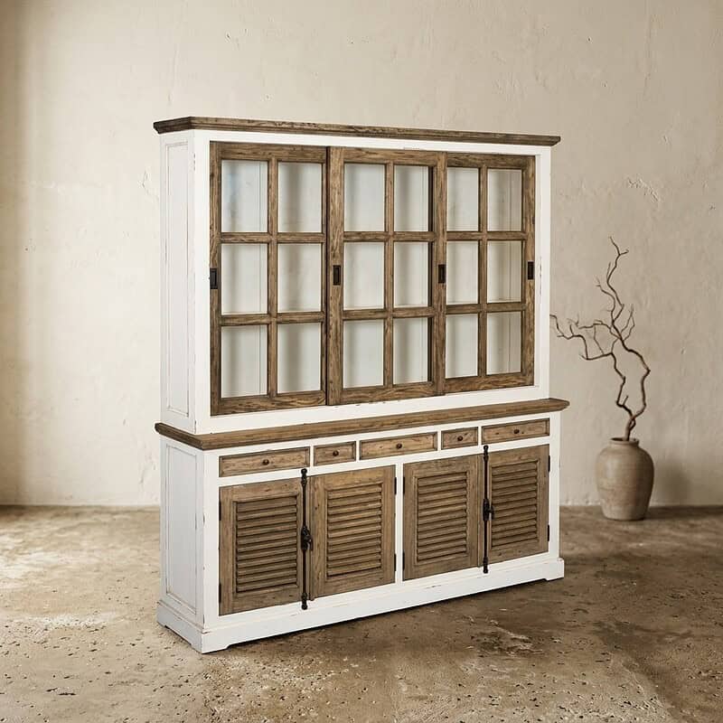 Vintage houten buffetkast met glazen deuren en louvredeuren onderaan, perfect voor landelijke of rustieke interieurstijlen. Gemaakt van massief hout met een witte afwerking en natuurlijke houtaccenten.
