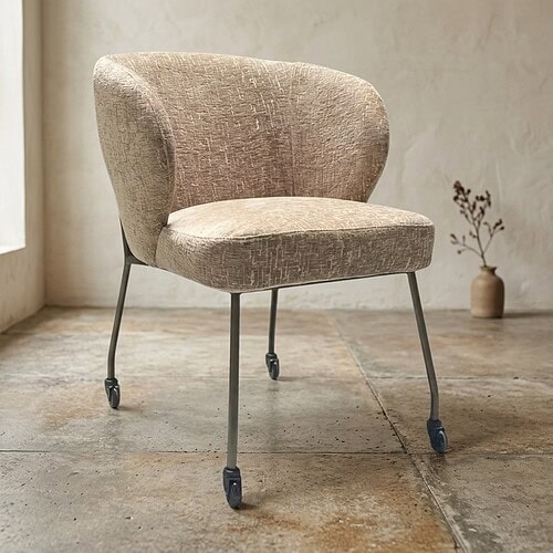 Comfortabele beige fauteuil met metalen poten en wieltjes, perfect voor moderne en vintage interieurs.