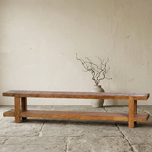 Rustieke houten bank met decoratieve vaas en takken, minimalistisch interieur, natuurlijke materialen, stijlvolle woonkamer inrichting, houten meubel, Scandinavisch design.