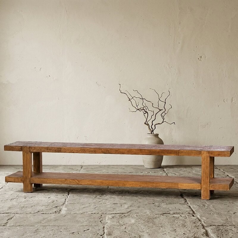 Rustieke houten bank met decoratieve vaas en takken, minimalistisch interieur, natuurlijke materialen, stijlvolle woonkamer inrichting, houten meubel, Scandinavisch design.