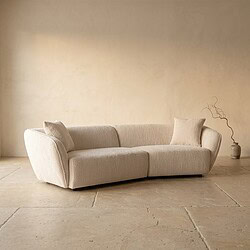 Bank met beige bekleding en kussens, minimalistisch interieur.