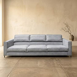 Moderne grijze bank in een minimalistische woonkamer, perfect voor stijlvolle en comfortabele zitplekken. Ideaal voor een eigentijdse inrichting met focus op comfort en design.