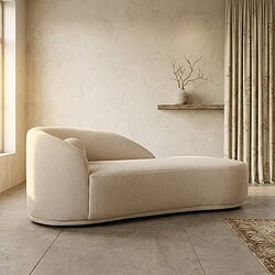 Moderne, beige loungebank in een minimalistisch interieur met natuurlijke lichtinval, een wandplank met decoratieve takken en een vloerkleed, perfect voor een stijlvolle woonkamer.