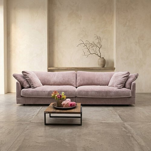 Elegante roze stoffen bank met kussens in een moderne, minimalistische woonkamer, perfect voor stijlvolle en comfortabele zithoeken.