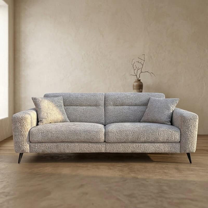 Moderne grijze bank met kussens in een minimalistisch interieur, perfect voor woonkamer decoratie.