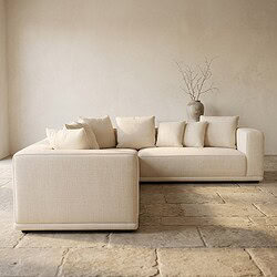 Moderne beige loungebank met kussens in een minimalistisch interieur, perfect voor een stijlvolle woonkamer.