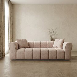 Ein Sofa mit weicher Polsterung und Kissen in einem minimalistischen Wohnzimmer.