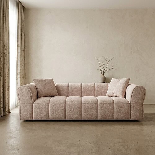 Ein Sofa mit weicher Polsterung und Kissen in einem minimalistischen Wohnzimmer.