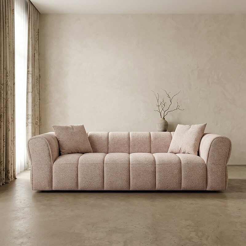 Ein Sofa mit weicher Polsterung und Kissen in einem minimalistischen Wohnzimmer.