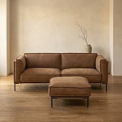 Luxe leren bank met voetenbank in een minimalistisch woonkamerinterieur, perfect voor stijlvolle en comfortabele zithoeken.