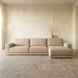 Ein modernes, beiges Ecksofa in einem schlichten, minimalistischen Wohnzimmer mit natürlichem Lichteinfall und einer schlichten Einrichtung. Perfekt für eine stilvolle und gemütliche Sitzecke.