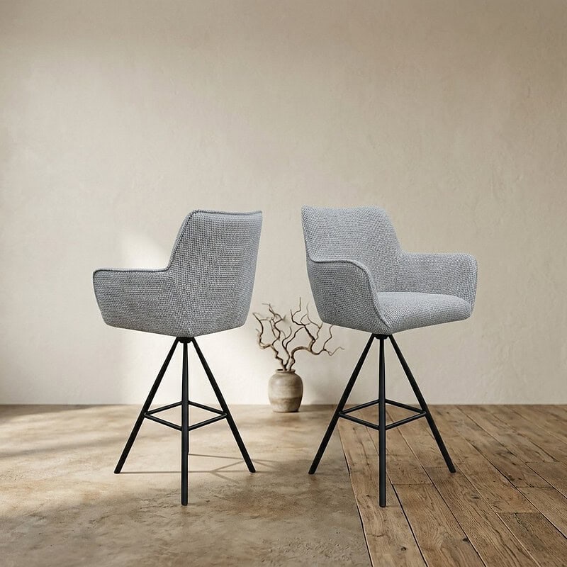 Moderne gestoffeerde stoelen met zwarte metalen poten, geschikt voor eetkamer of kantoor, in een minimalistische interieursetting.