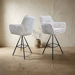 Twee moderne gestoffeerde eetkamerstoelen met zachte bekleding en zwarte metalen poten, geplaatst op een houten vloer met een neutrale achtergrond.