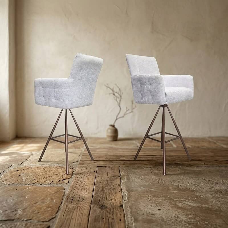 Twee moderne witte eetkamerstoelen met metalen poten op een houten vloer, geschikt voor een eigentijdse eetkamer of woonkamer.