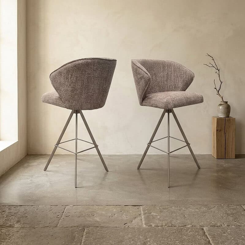 Twee moderne gestoffeerde eetkamerstoelen met metalen poten in een minimalistische interieursetting, perfect voor een stijlvolle eetkamer of woonkamer.