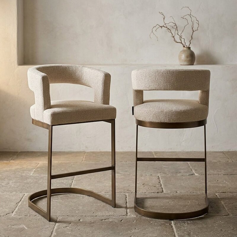 Twee stijlvolle eetkamerstoelen met beige bekleding en houten frame, geschikt voor een moderne eetkamer of keuken, gecombineerd met een minimalistisch interieur.