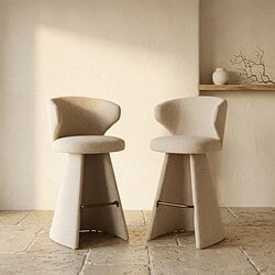 Twee beige barkrukken met comfortabele rugleuning en stevige basis, ideaal voor moderne keukens en bars, ontworpen door Mokana Meubelen.