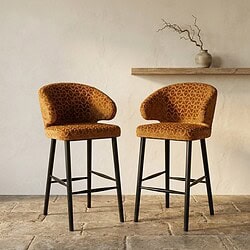 Moderne barkrukken met oranje bekleding en zwarte houten poten, ideaal voor een stijlvolle keuken of bar. Perfecte combinatie van comfort en design, gemaakt door Mokana Meubelen.
