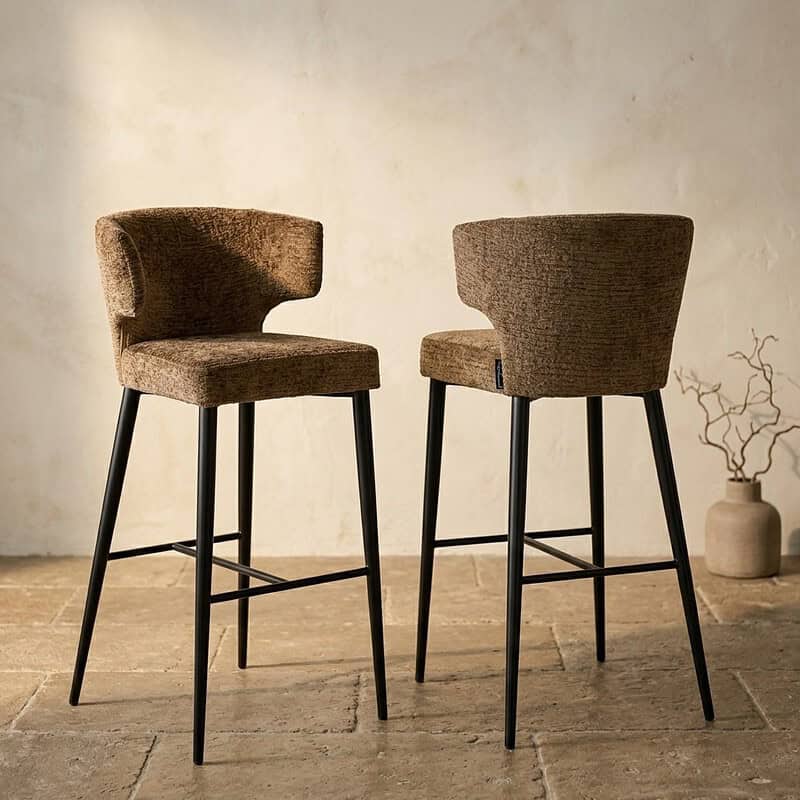 Zwei stilvolle Barhocker mit Holzbeinen und Stoffsitzen, ideal für eine moderne Küche oder Bar. Die perfekte Kombination aus Komfort und Design, hergestellt von Mokana Meubelen.