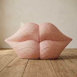 Kunstzinnige keramische sculptuur in de vorm van vrouwelijke lippen, geplaatst op houten vloer, geschikt voor interieurdecoratie en kunstcollecties.
