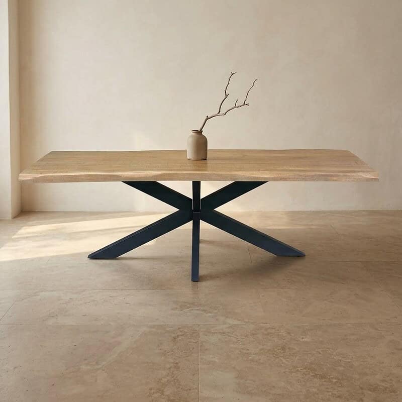 Moderne eettafel met houten blad en zwart onderstel, minimalistisch interieur.