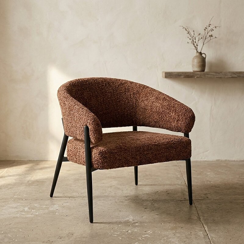 Moderne fauteuil met zachte, bruine bekleding en zwarte poten, perfect voor een stijlvolle en comfortabele zithoek. Ontdek hoogwaardige meubelen bij Mokana Meubelen voor een eigentijdse interieurstijl.