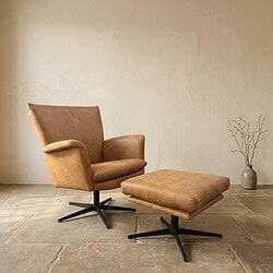 Luxe houten relaxfauteuil met voetenbank in een minimalistische woonkamer, perfect voor ontspanning en stijl.