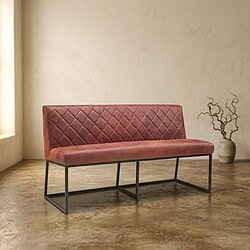 Modern vintage bank met quilted bekleding en metalen frame in een minimalistische interieurstijl. Moderne vintage bank met quilted bekleding en zwart metalen frame, perfect voor een stijlvolle woonkamer of kantoorruimte.