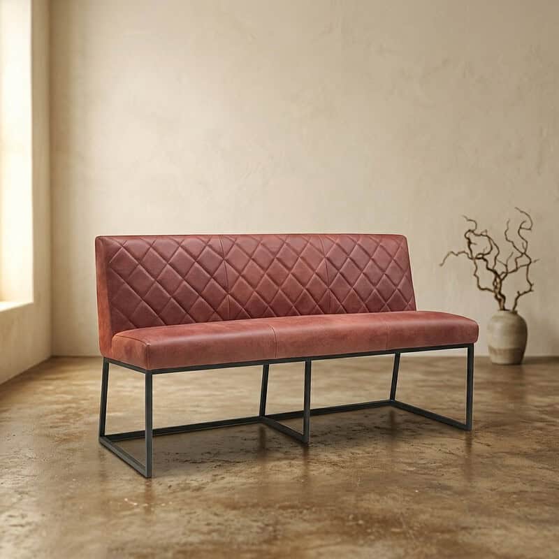 Modern vintage bank met quilted bekleding en metalen frame in een minimalistische interieurstijl. Moderne vintage bank met quilted bekleding en zwart metalen frame, perfect voor een stijlvolle woonkamer of kantoorruimte.