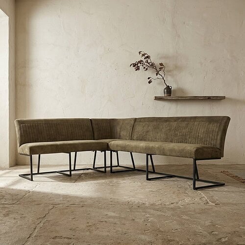 Modernes Ecksofa aus grünem Samt mit schwarzen Metallbeinen, perfekt für ein stilvolles Wohnzimmer.