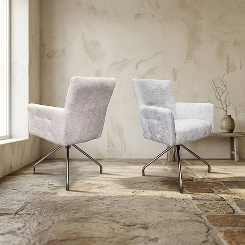 Moderne witte fauteuils in een lichte woonkamer met een rustieke vloer en een eenvoudige decoratie, perfect voor een stijlvolle en comfortabele zithoek.