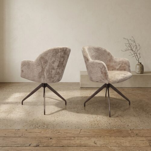 Zwei stilvolle, weiche Stoffsessel mit schwarzen Metallbeinen in einer minimalistischen Einrichtung – perfekt für eine gemütliche Sitzecke.