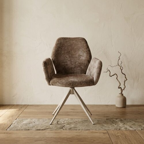 Comfortabele stoffen fauteuil met houten poten, perfect voor een modern interieur, geplaatst op een houten vloer naast een decoratieve vaas met takken.