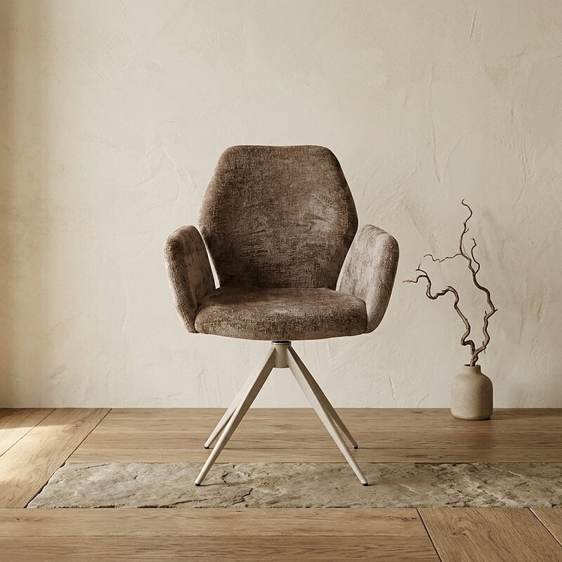 Comfortabele stoffen fauteuil met houten poten, perfect voor een modern interieur, geplaatst op een houten vloer naast een decoratieve vaas met takken.