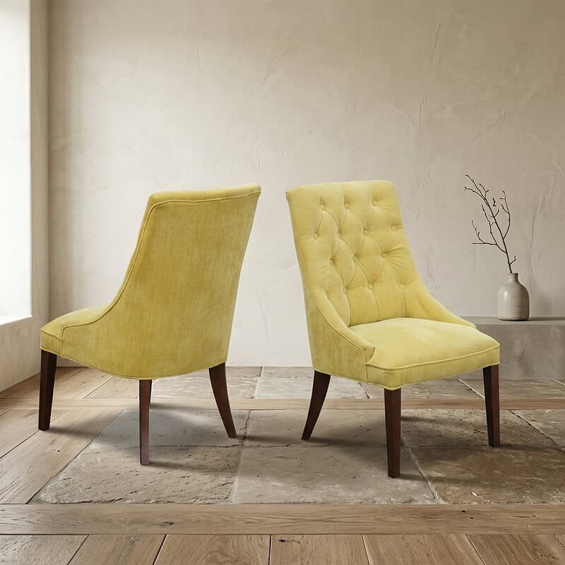 Mokana Meubelen - Gele vintage fauteuils in woonkamer Twee gele vintage fauteuils met houten poten in een minimalistische woonkamer, perfect voor een stijlvolle en comfortabele zithoek.